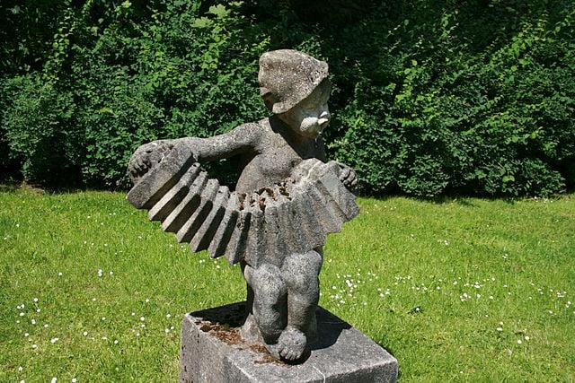 A statue of a child playing an accordion is shown.