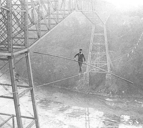 An old picture shows a man on a tight rope crossing Niagara River.