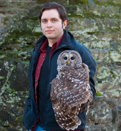 The image shows Fabian de Kok-Mercado, M.A., holds a barred owl..