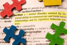 The image shows multi-colored jigsaw pieces around a dictionary definition of autism.