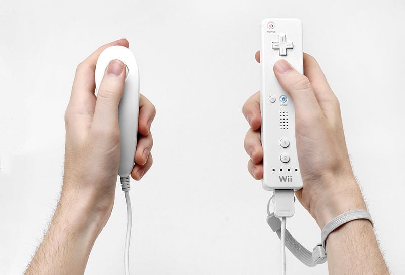 The image shows a person using a Wii game controller.
