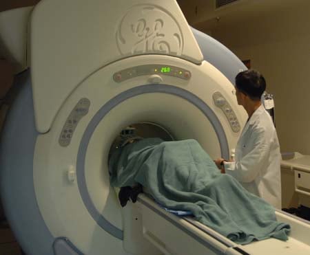 The image shows a patient undergoing MRI neuroimaging.