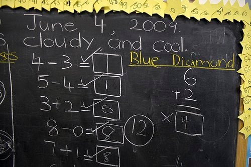 This image shows some basic math problems on a blackboard.