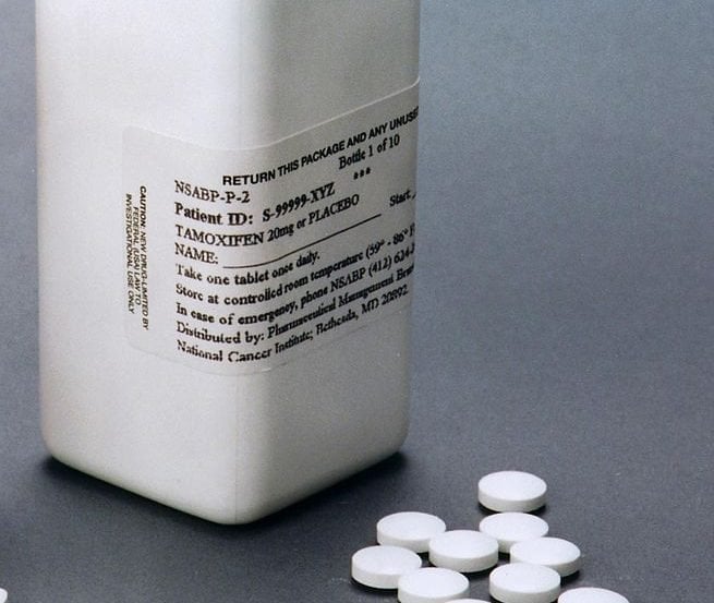 This image shows a bottle and some tamoxifen pills.