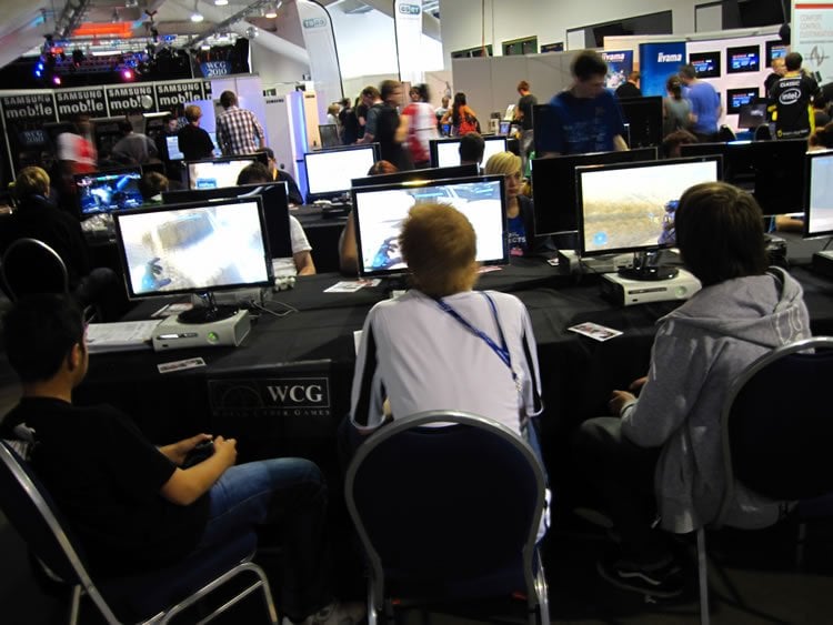 This image shows people playing online games in what appears to be an online gaming conference.