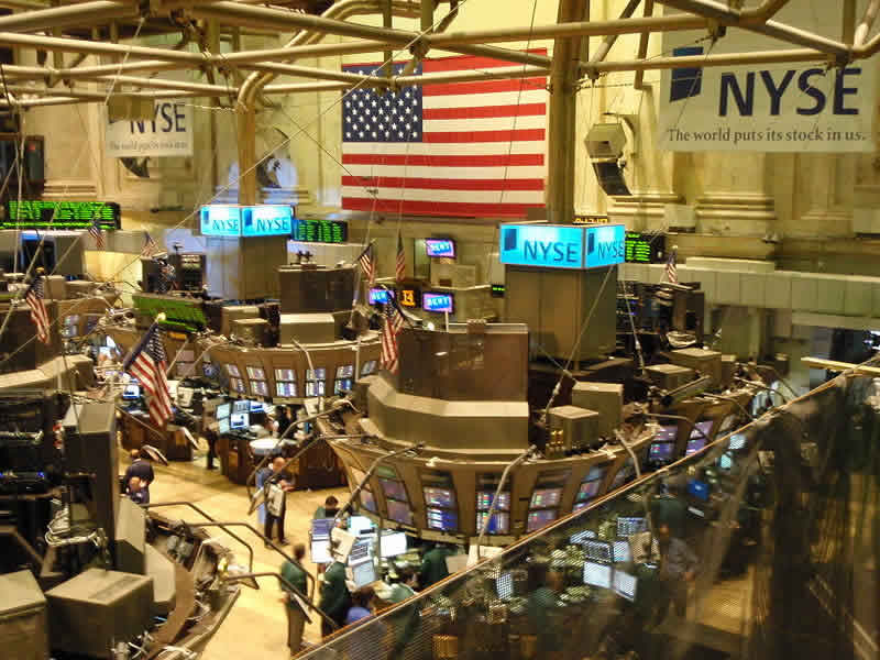 The image shows the trading floor in the New York Stock Exchange.