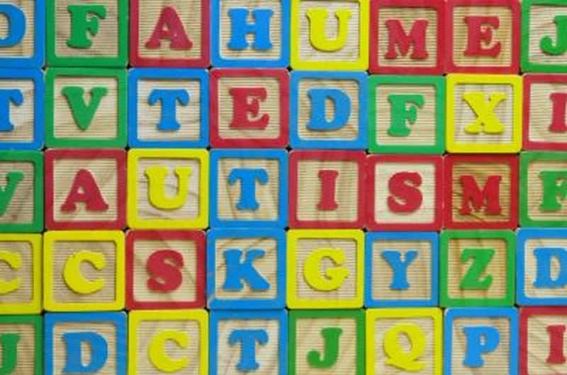 The image shows the word Autism spelled out in building blocks.
