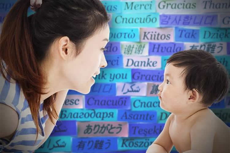 The image shows a woman and a small child in front of a wall covered in words.