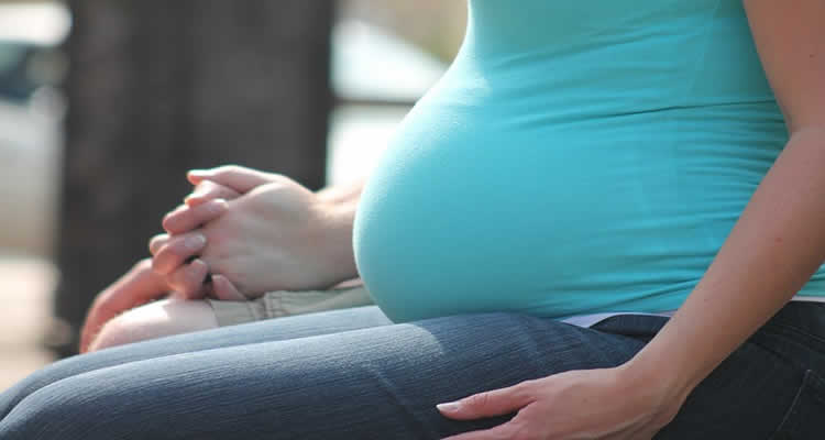 The image shows a woman with a pregnancy baby bump.