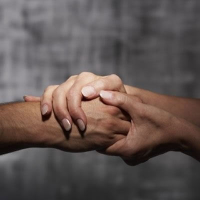 This image shows two people holding hands.