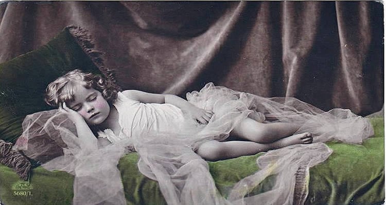 The image shows a vintage postcard of a sleeping child.