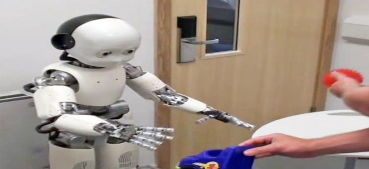 Images shows a childlike robot reaching for a hat.