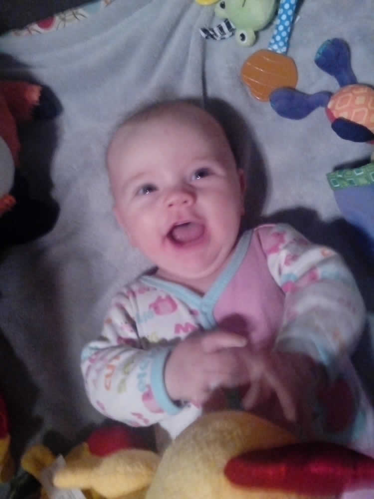 This image shows the most amazing baby ever with her toys.