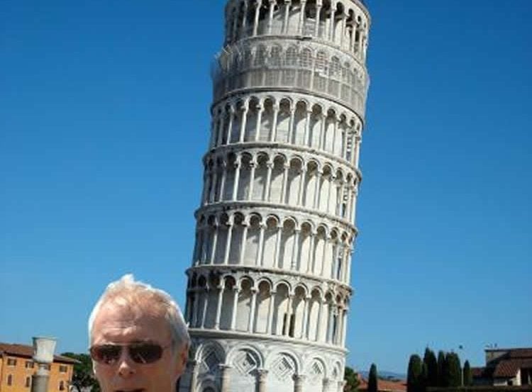 This image shows Clint Eastwood in front of the Leaning Tower of Pisa.