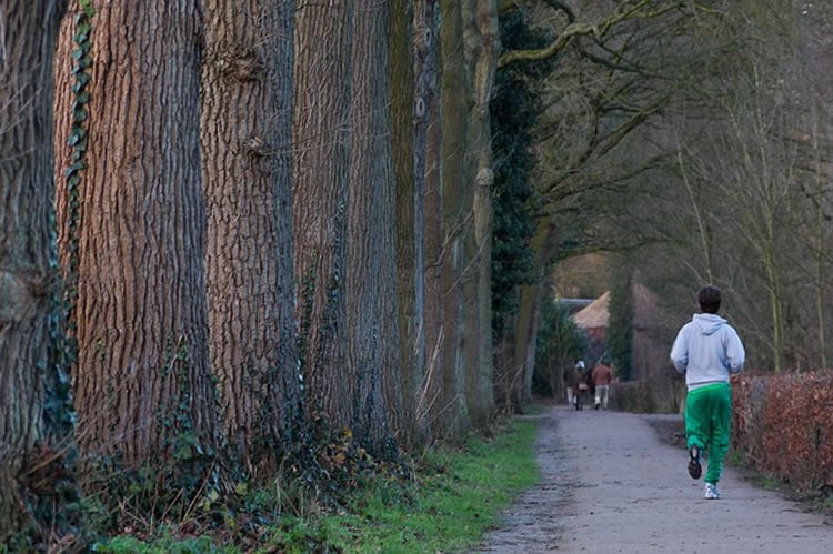 This image shows a man jogging on a country lane.