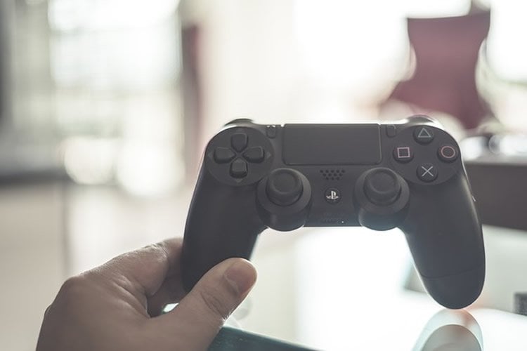 This image shows a hand holding a play station controller.