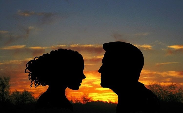 This shows the outline of a man and woman in the sunset.