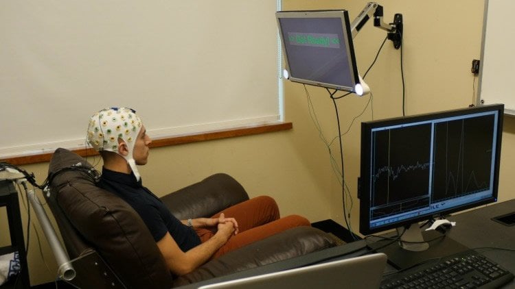 Photo of a participant in the brain to brain communication experiment in an eeg cap.