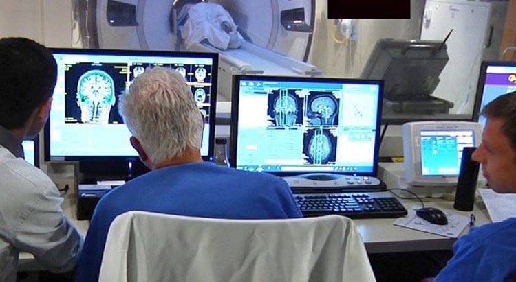 Image shows researchers looking at brain scans.