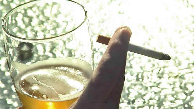 Image of a glass of beer and a cigarette.