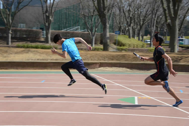 This image shows two people running a relay race.