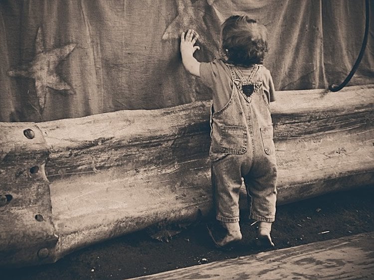 Photo of a toddler touching a wall.