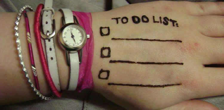Photo of a hand with a "to do" list written on it.