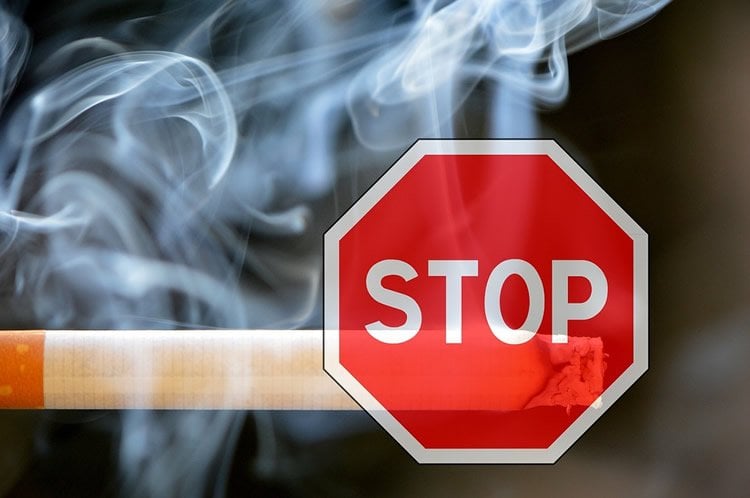 Image shows a cigarette and a stop sign.