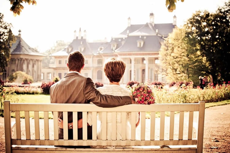 Photo of a couple sitting on a bench.