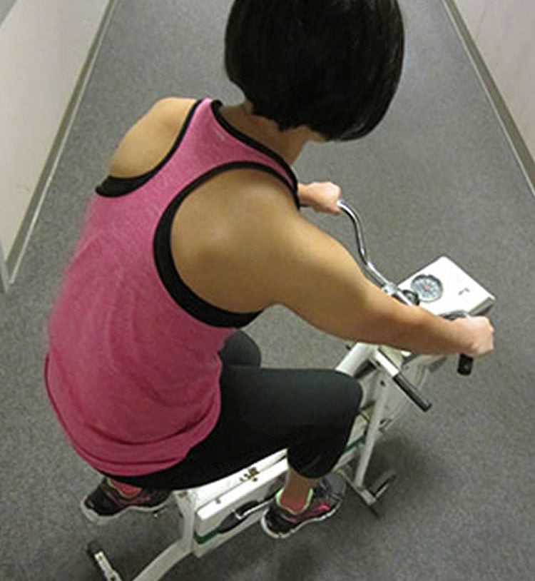 Image shows a woman on an exercise bike.
