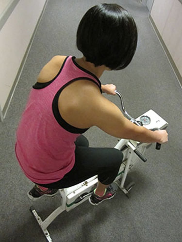 Image shows a woman on an exercise bike.