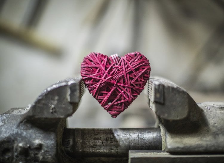 Image shows a heart in a vice.