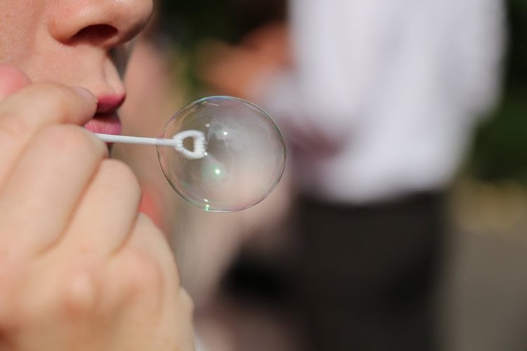 Photo of a child blowing bubbles.