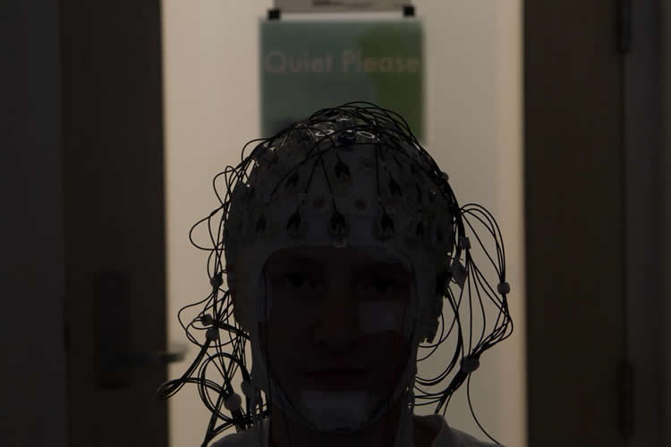 Image shows a person in an EEG helmet.