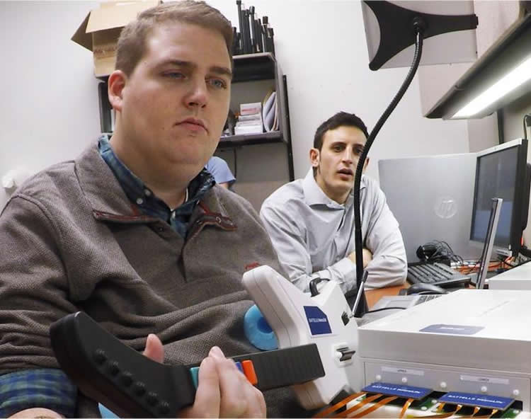 Photo shows Ian Burkhart playing a video game with his functional hand.