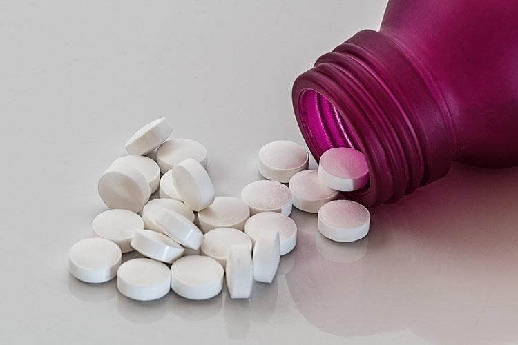 Image shows a bottle and pills.