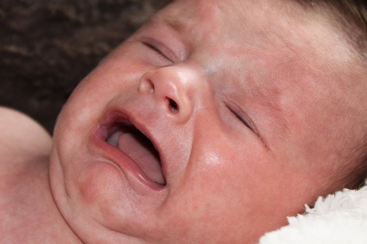 Image show a crying newborn.