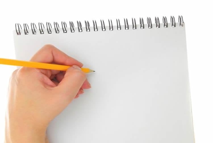 Photo of a person writing left handed.