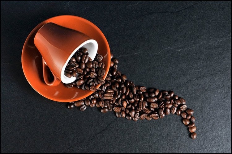 Image shows a cup and coffee beans.
