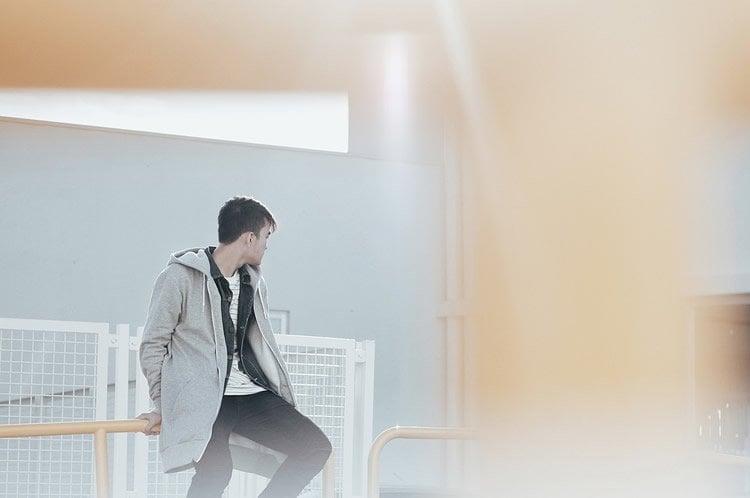 A young man against a wall.