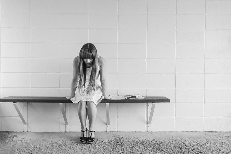 Image shows a depressed looking teen girl.