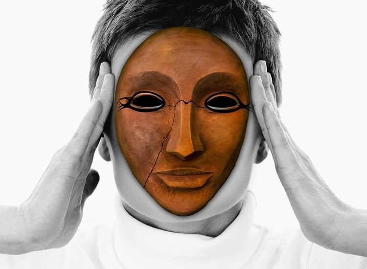Image shows a woman in a wooden mask.