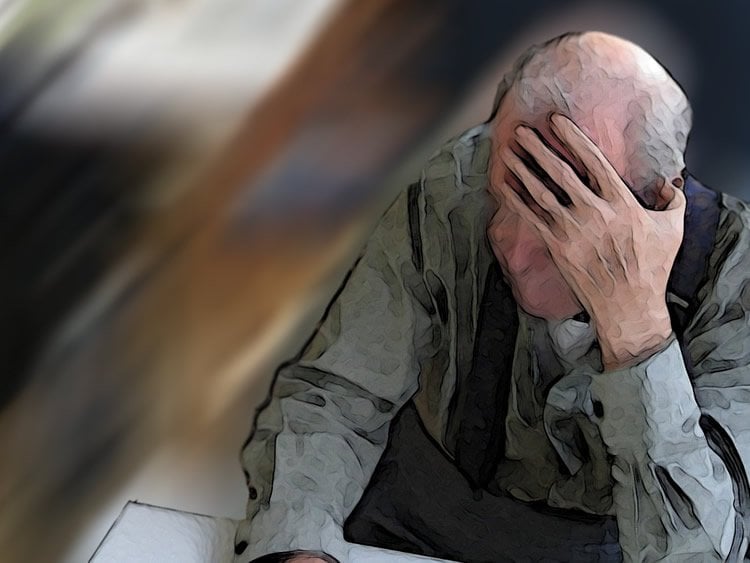 Image shows an old man holding his head.