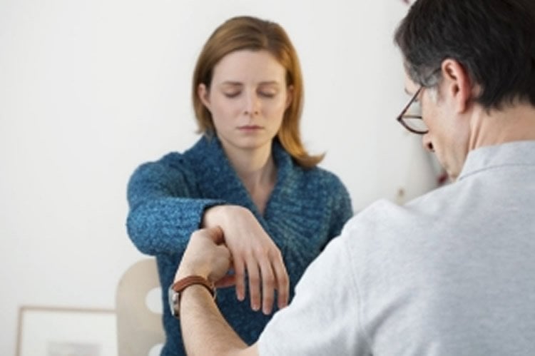 Image shows a woman being hypnotized.