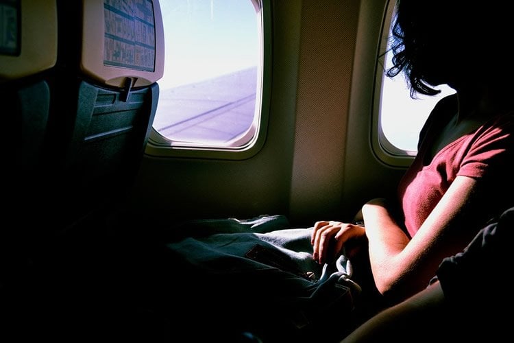 Image shows a woman on an airplane.