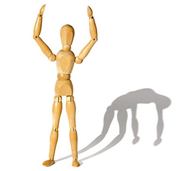 Image shows an artist wooden model standing with a shadow that is slumped over.