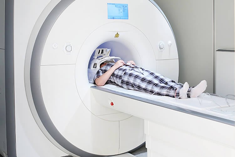 Image shows a person in an MRI scanner.