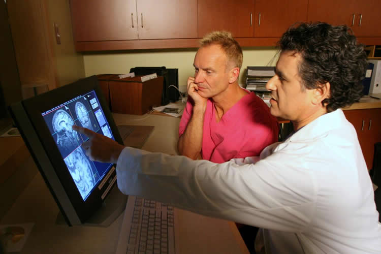 Image shows the researcher showing Sting his brain scan.