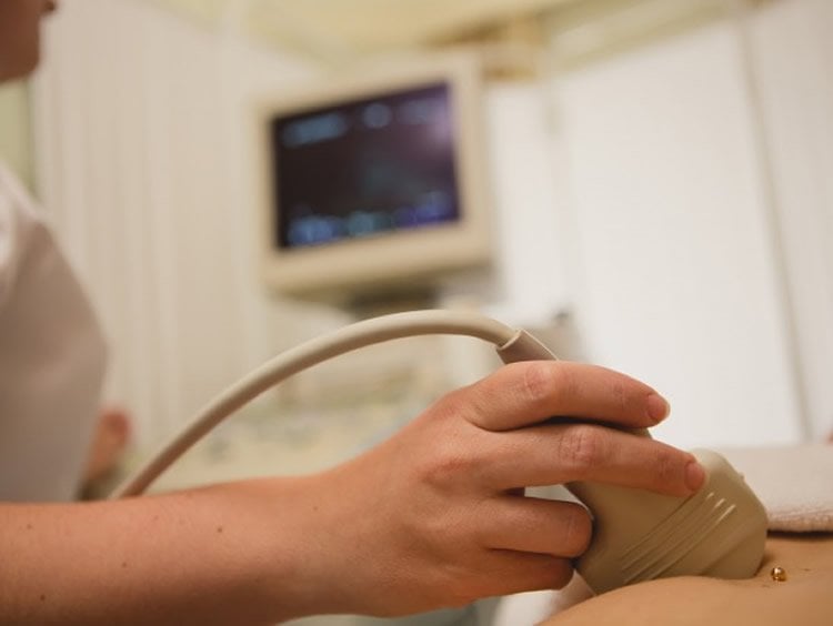 Image shows a woman undergoing an ultrasound.