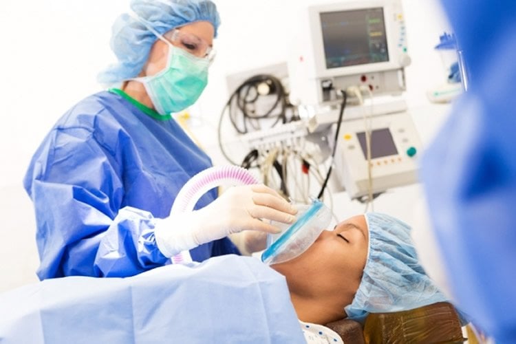 Image shows a person in surgery.